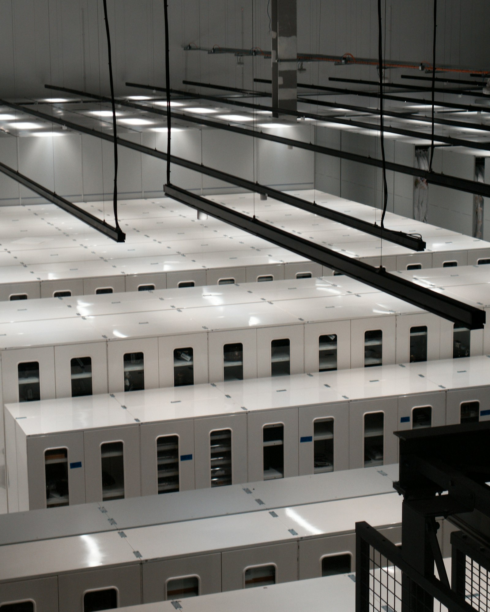 A data centre hall with rows of white server cabinets